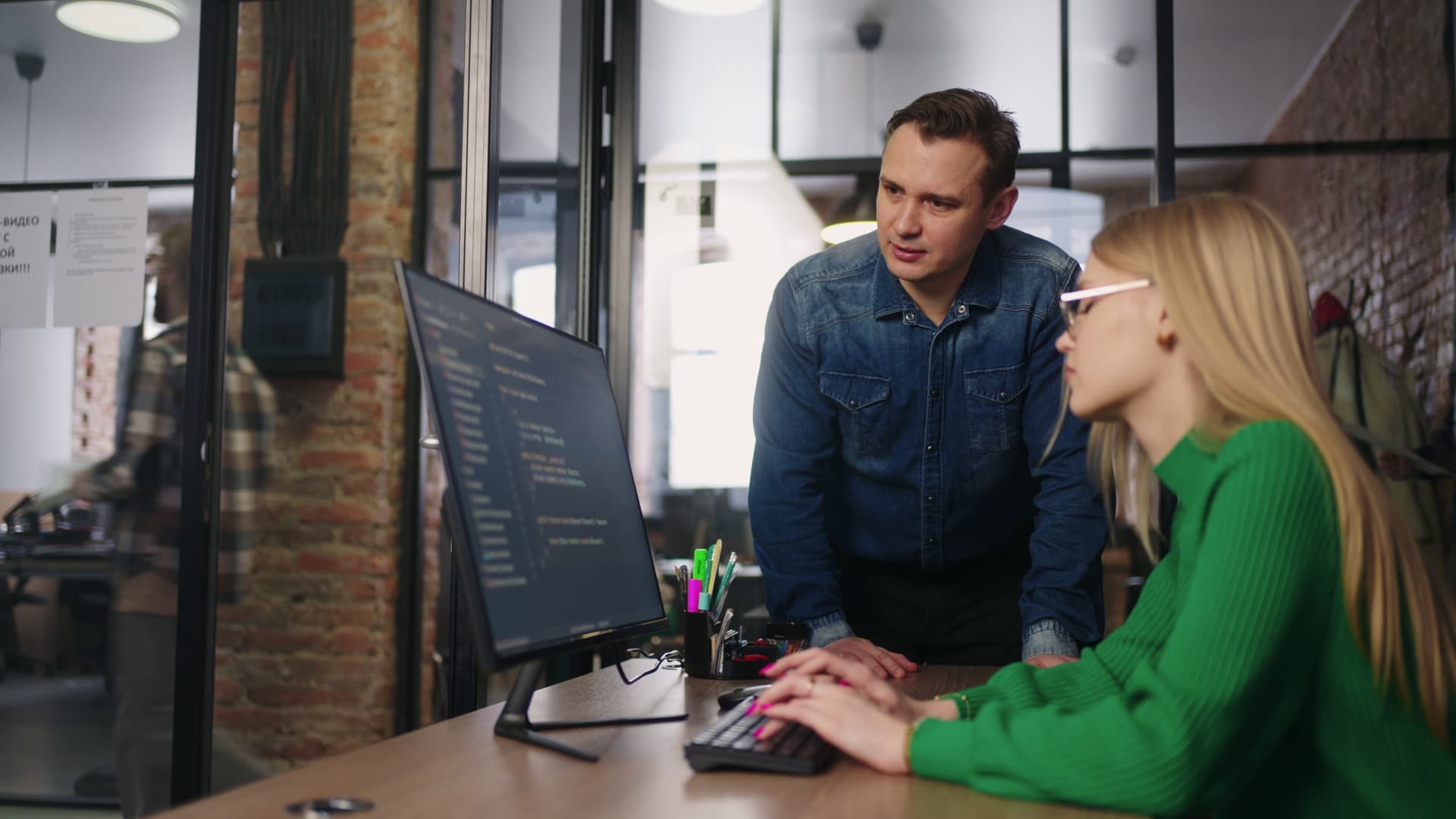 An engineer coaching a colleague through code on her screen